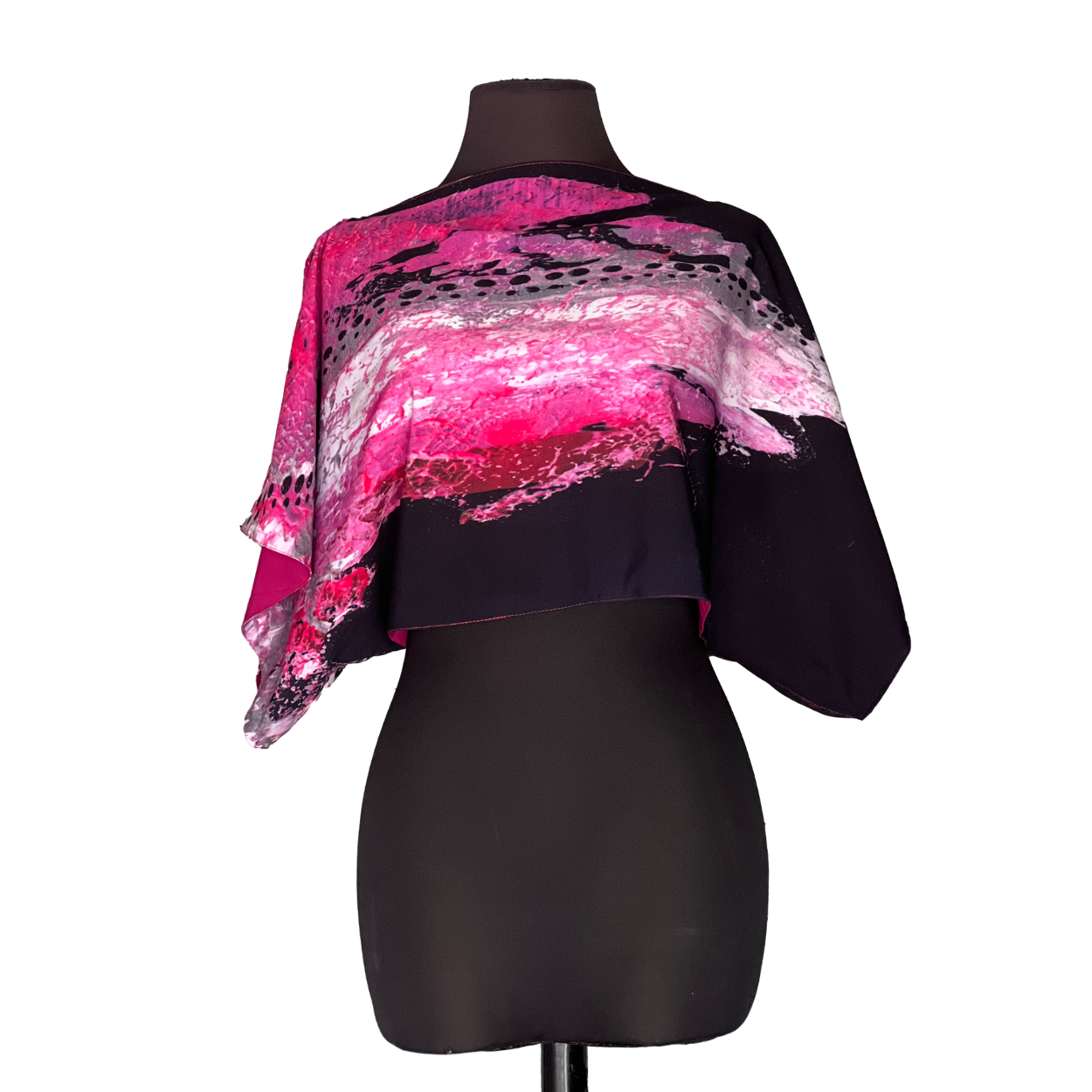 Pink and black printed poncho on a black mannequin.