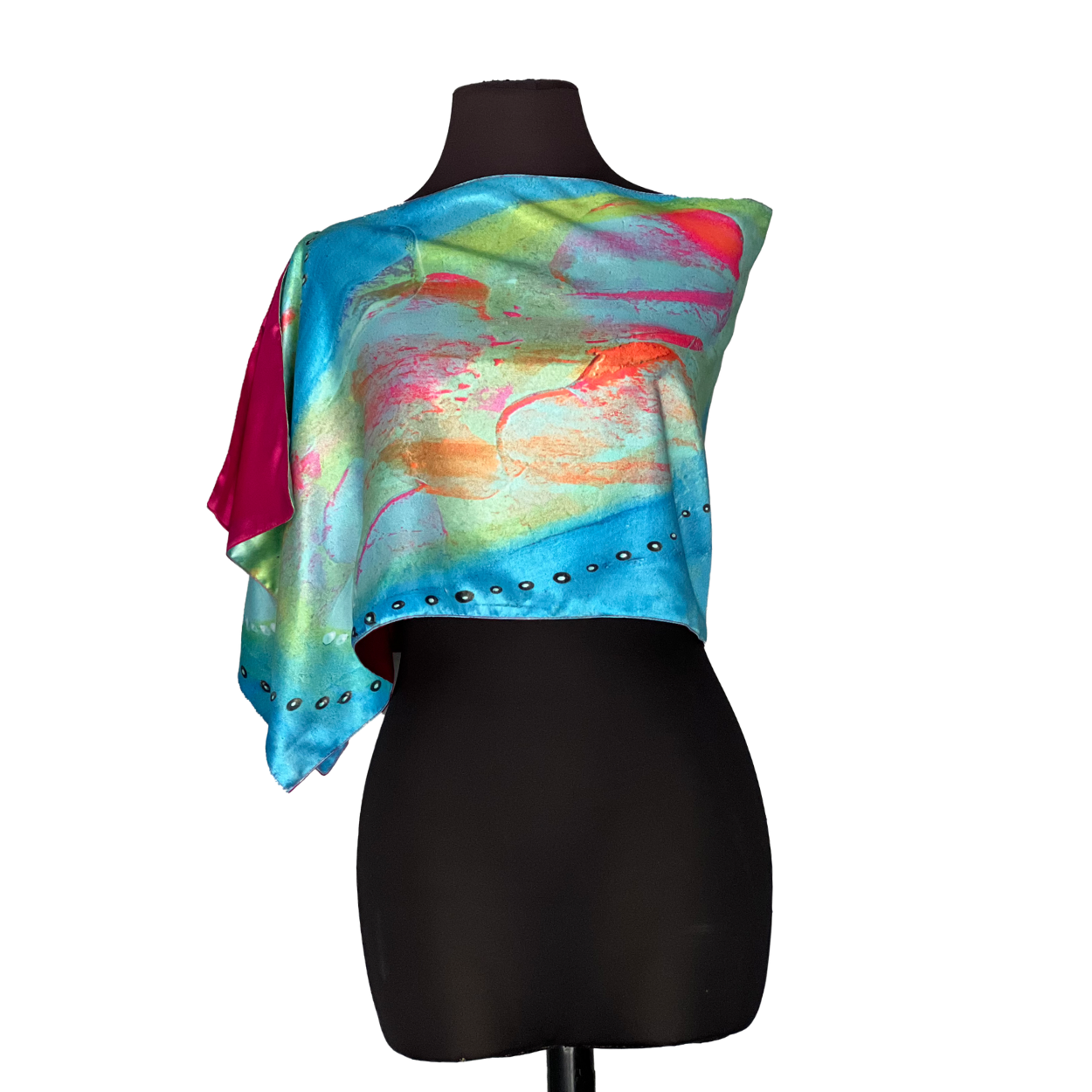 Colorful silk scarf draped on a black mannequin, featuring blue, green, and pink abstract patterns.