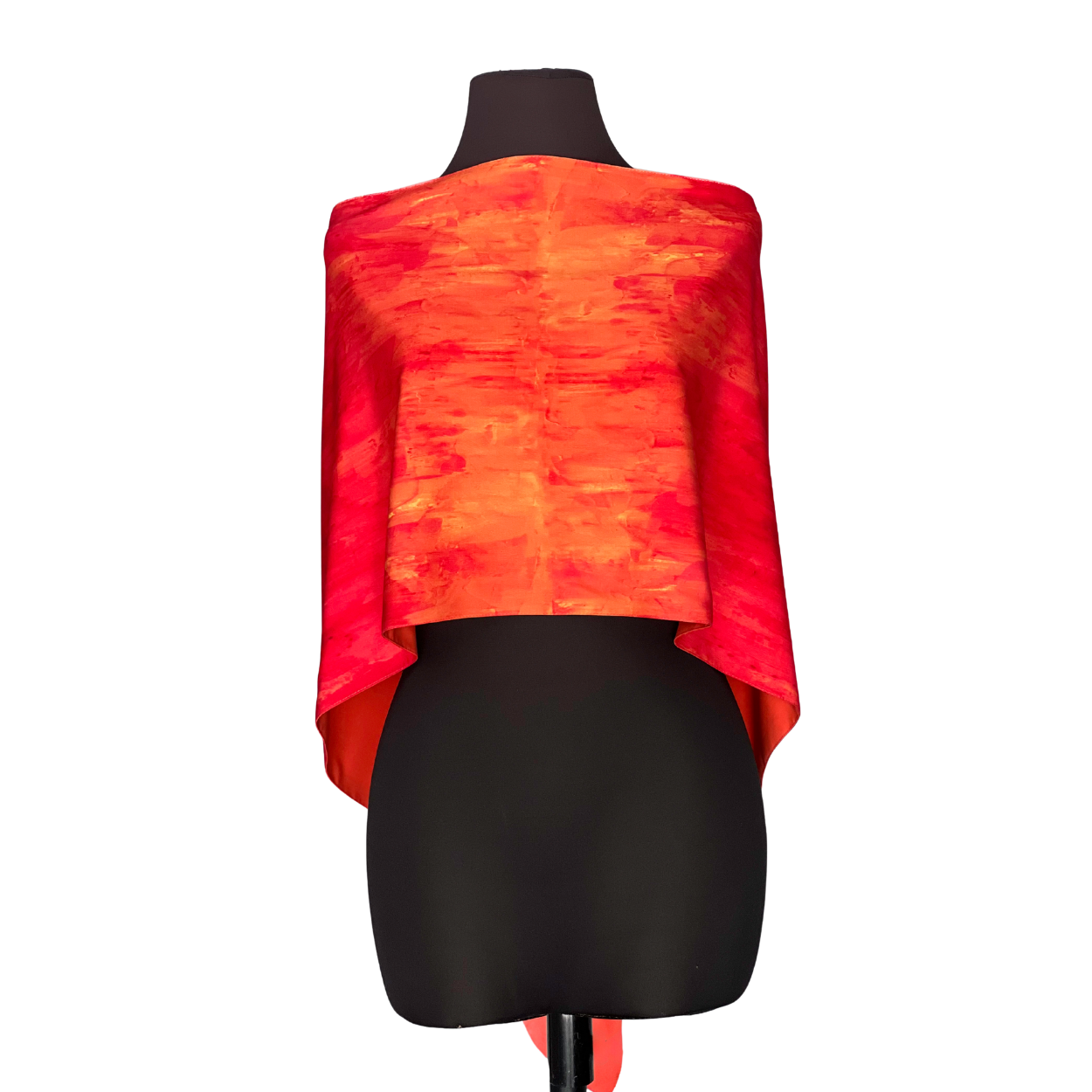 Orange and red silk poncho on a black mannequin.