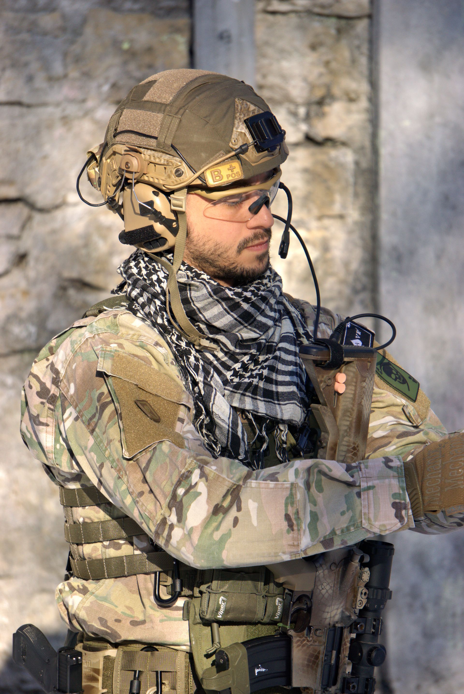 Ein Mann in Militäruniform trägt einen Helm und einen Schal.