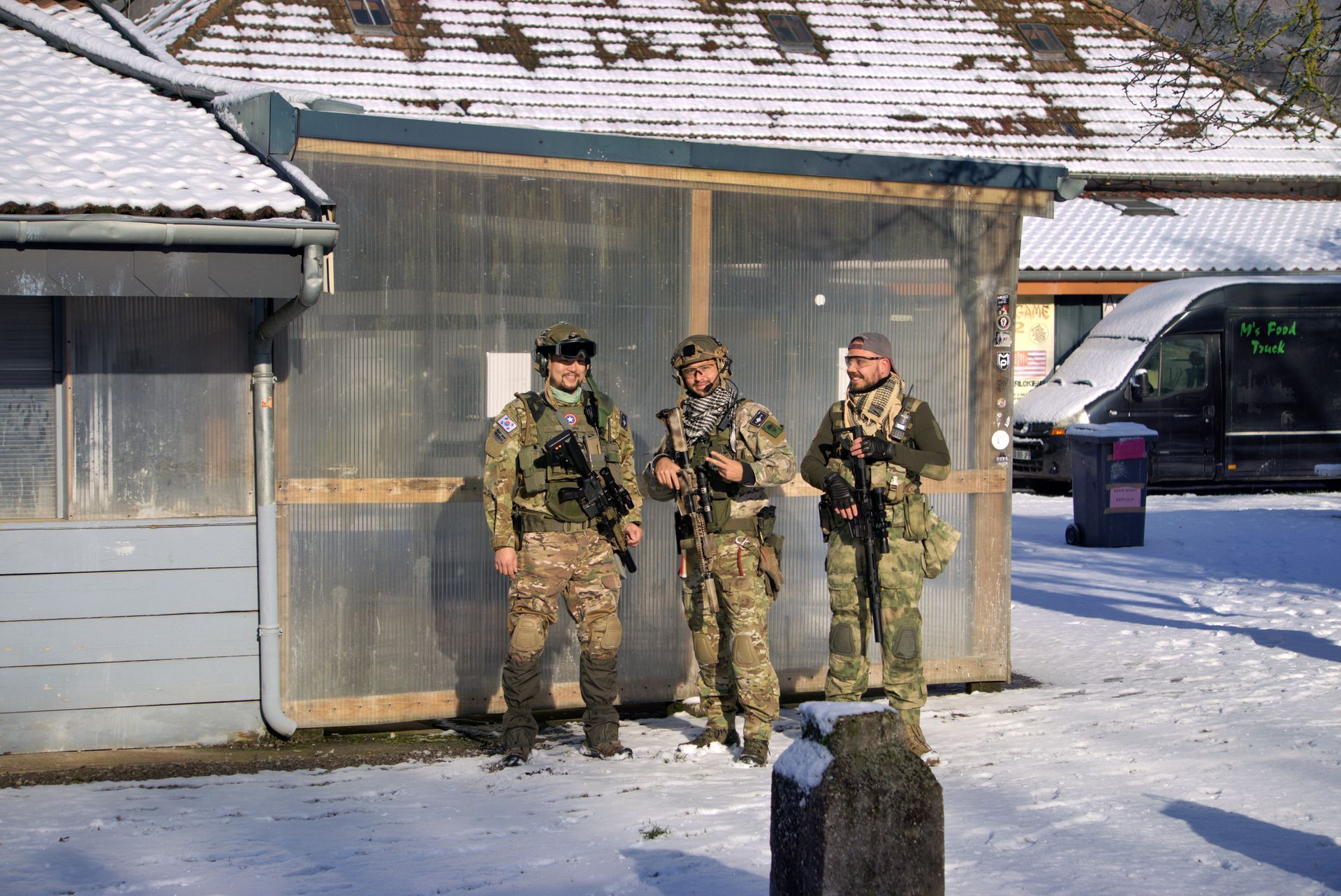 Drei Soldaten stehen im Schnee vor einem Gebäude.