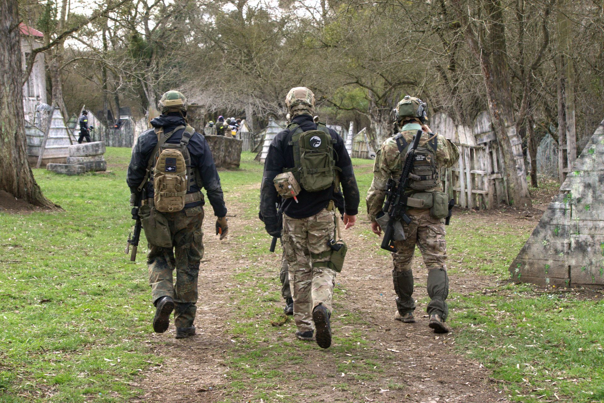 Drei Soldaten gehen einen Feldweg entlang.
