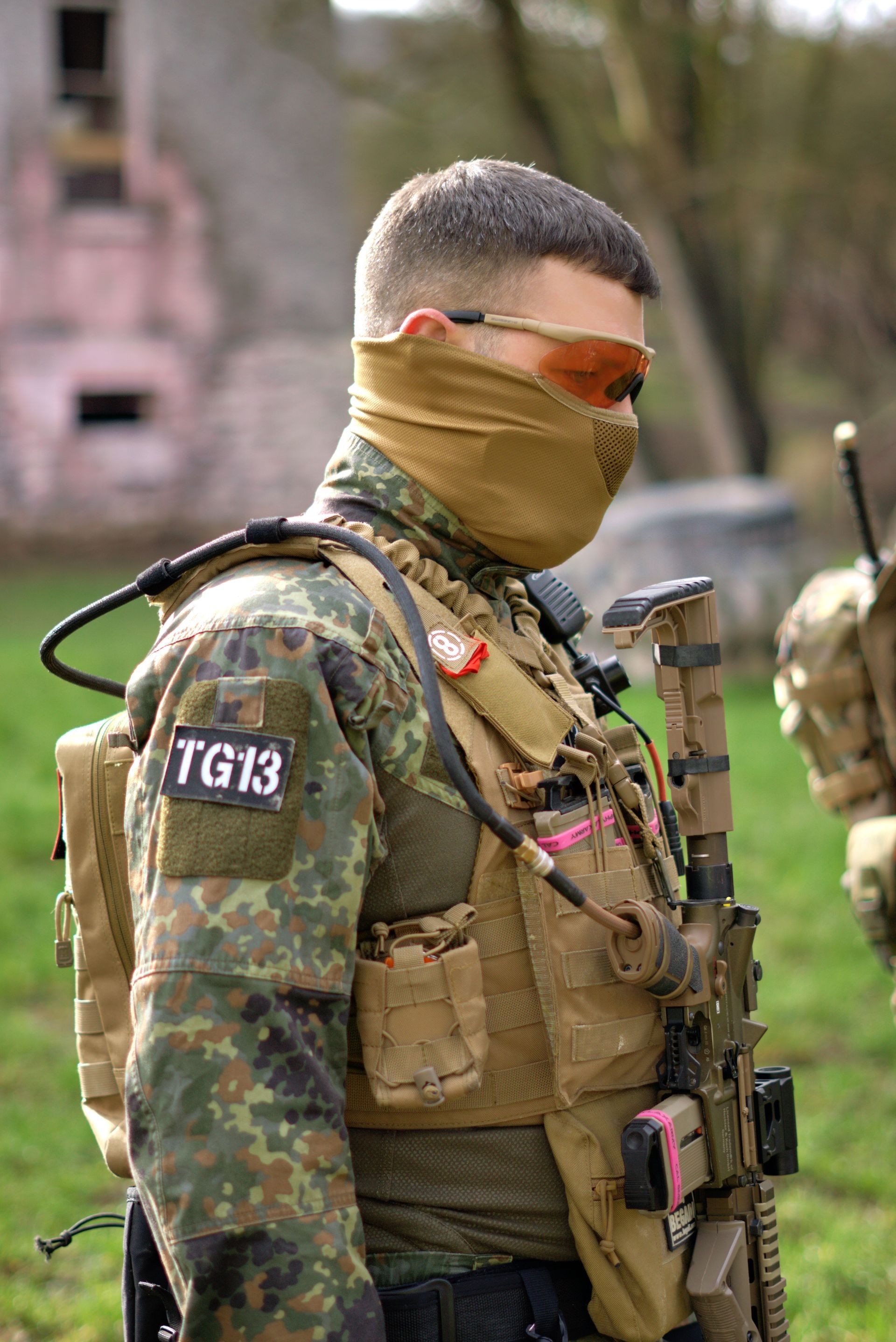 Ein Mann in Militäruniform trägt eine Maske und eine Sonnenbrille.
