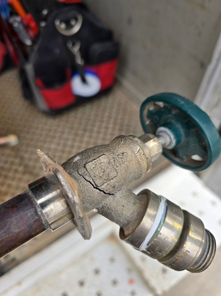 A close up of a broken faucet with a green handle.