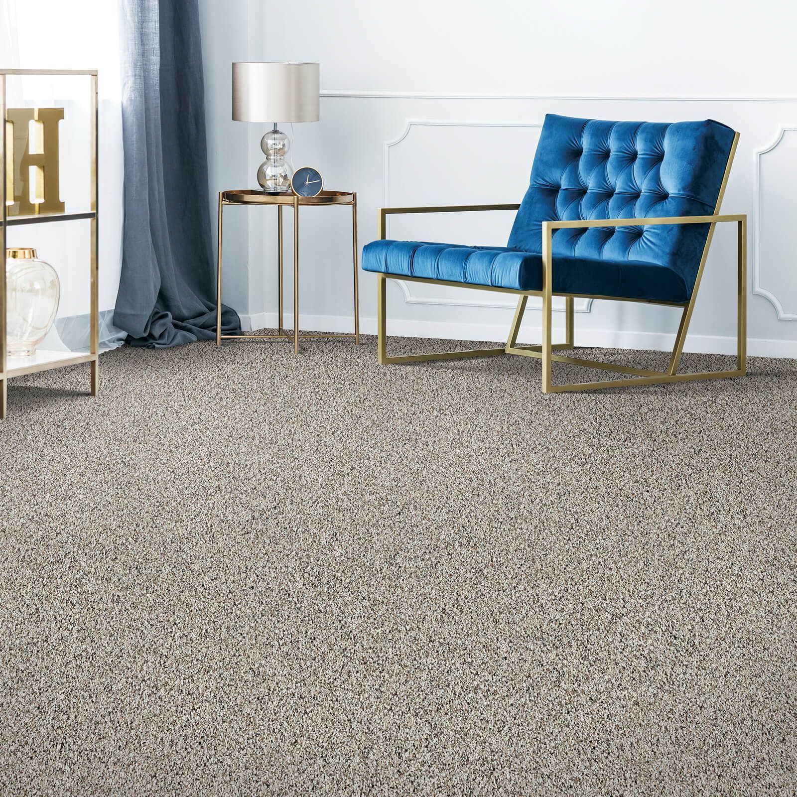 A living room with a blue chair and a carpeted floor.