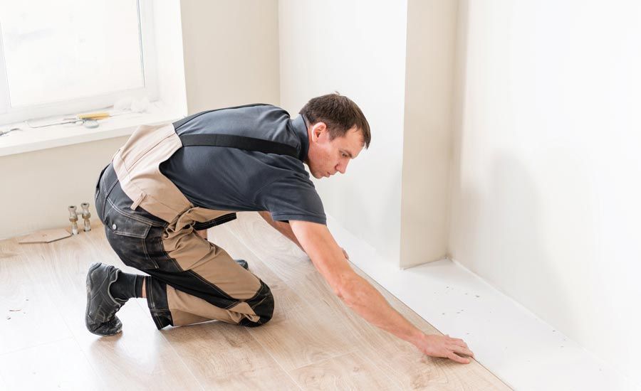 A man is kneeling on the floor in a room.