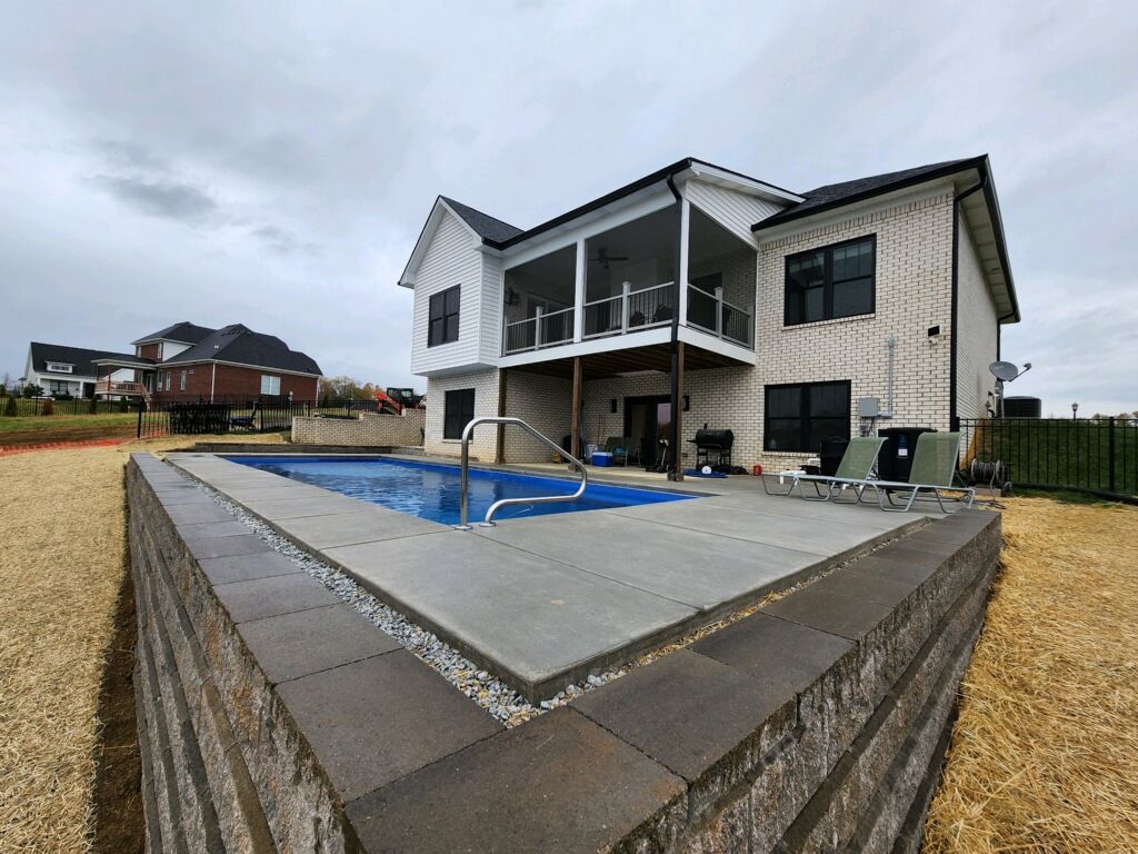 Modern two-story house with a covered patio and pool in a fenced backyard