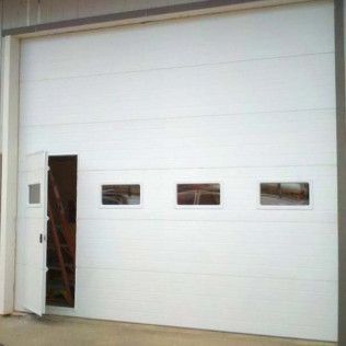 A white garage door with three windows and a door open.