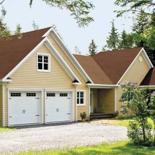 A house with two garage doors and a brown roof