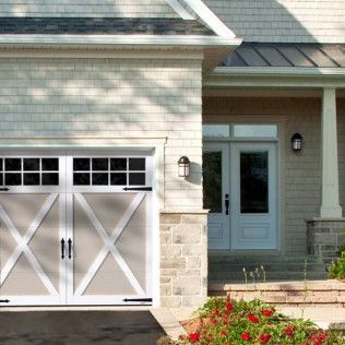 A white house with a large garage door and a porch.