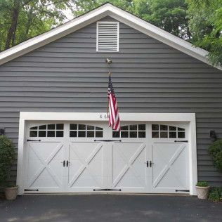 A large white garage door with an american flag hanging from it.