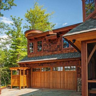 A large wooden garage door is next to a large house.