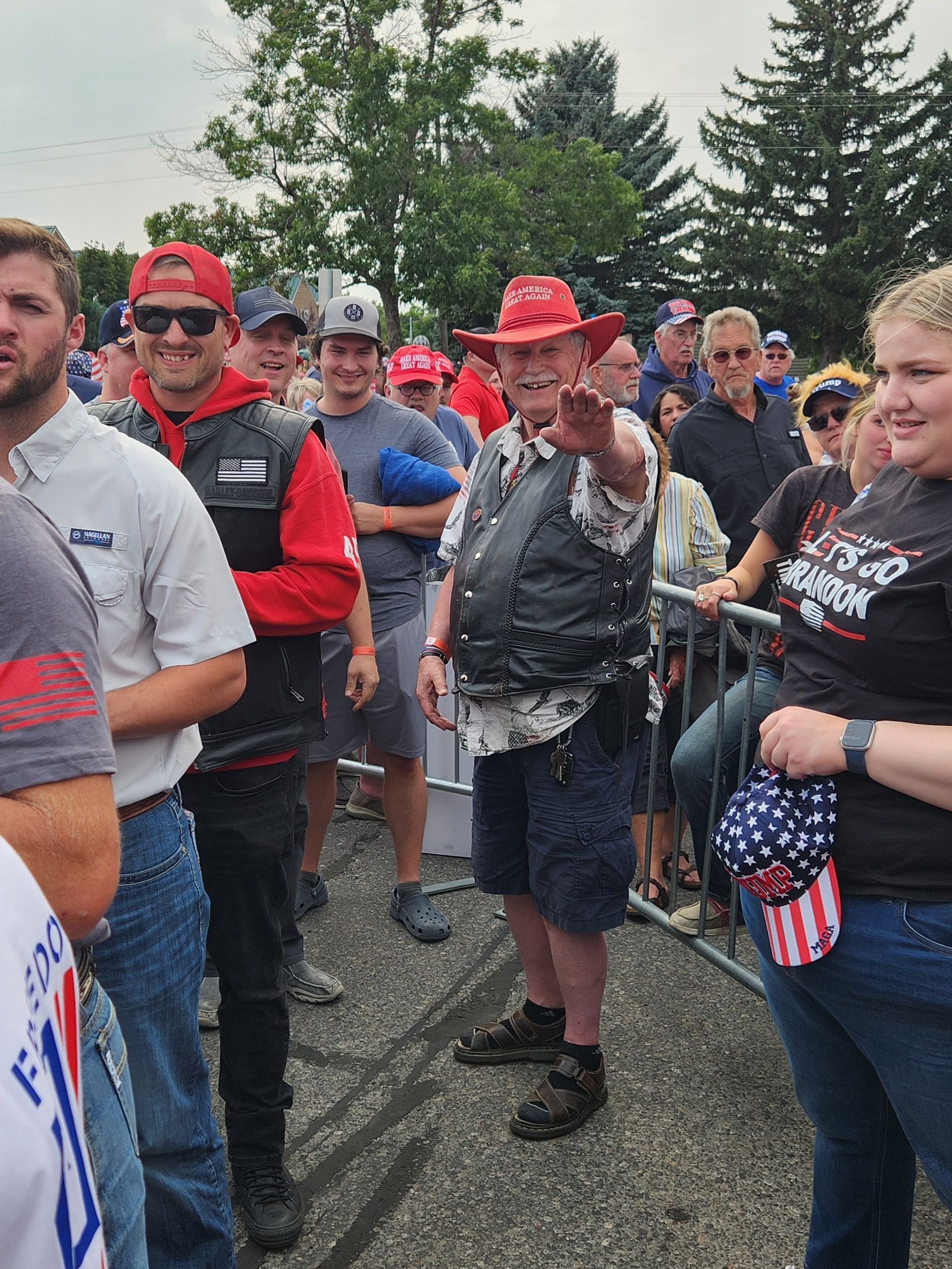 A group of people are standing in a parking lot.