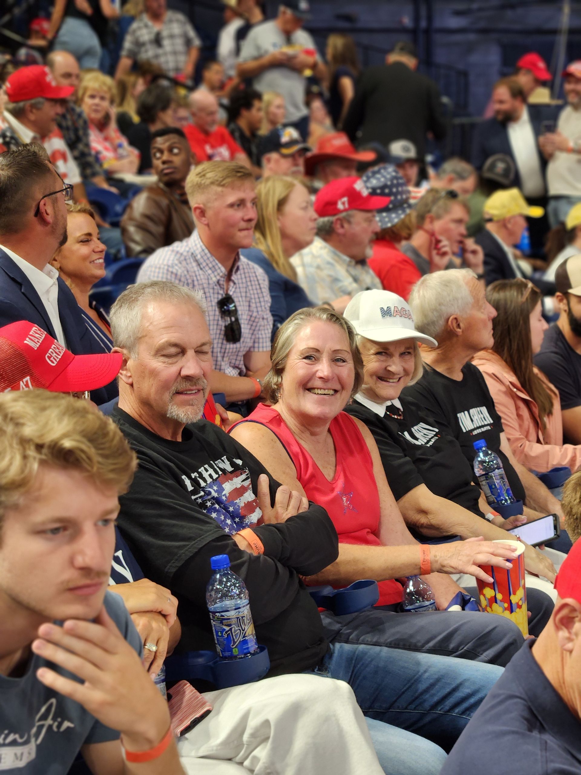 A large group of people are sitting in a stadium watching a game.