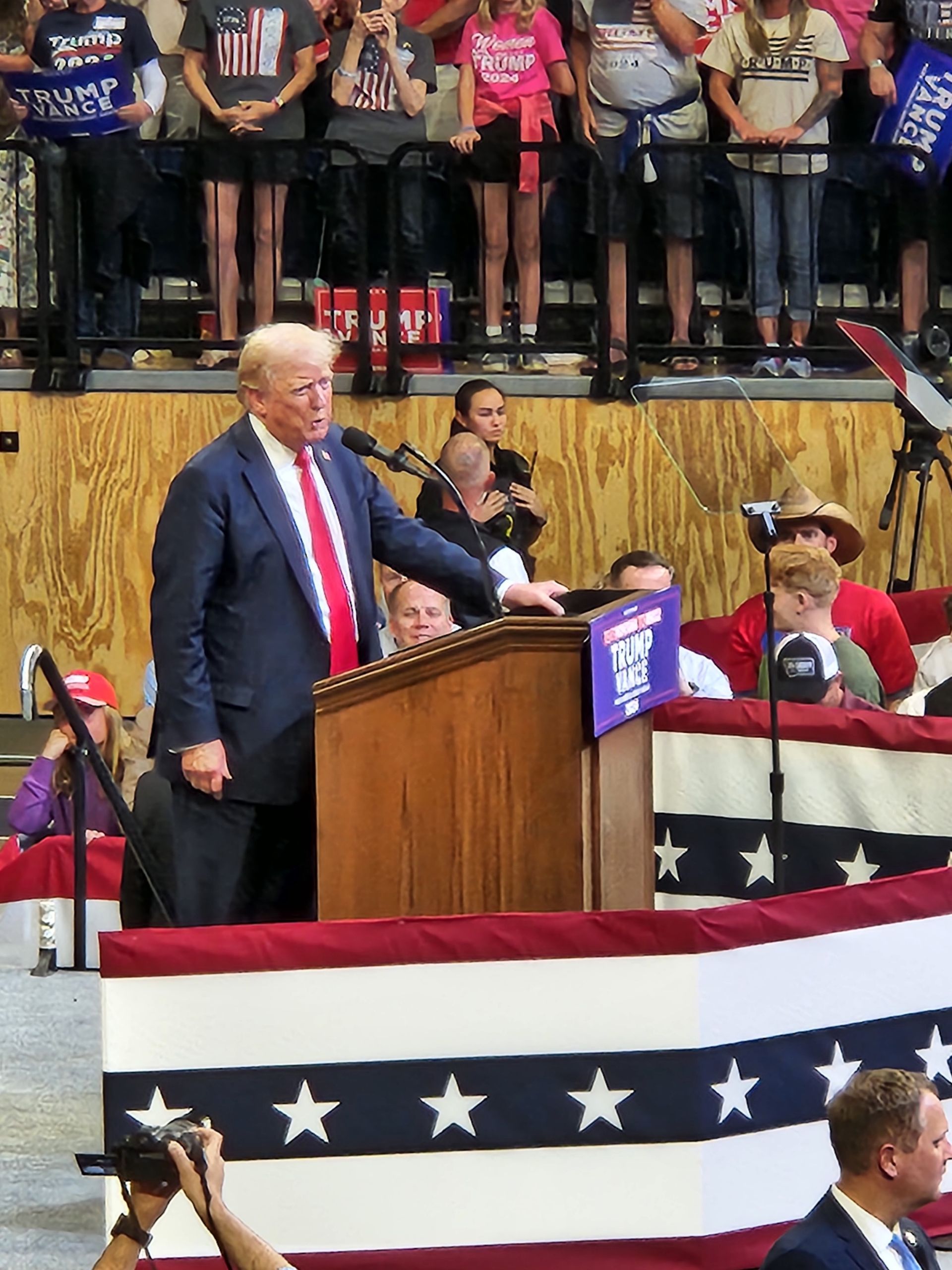 A man in a suit and tie is giving a speech at a podium