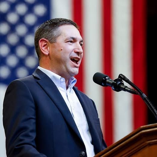 AG Austin Knudsen portrait with Gallatin County Courthouse and Montana flag - Demands Reverse ICE Po