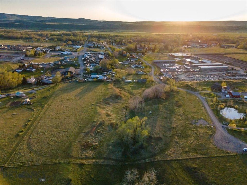 An aerial view of a small town in the middle of a field at sunset.