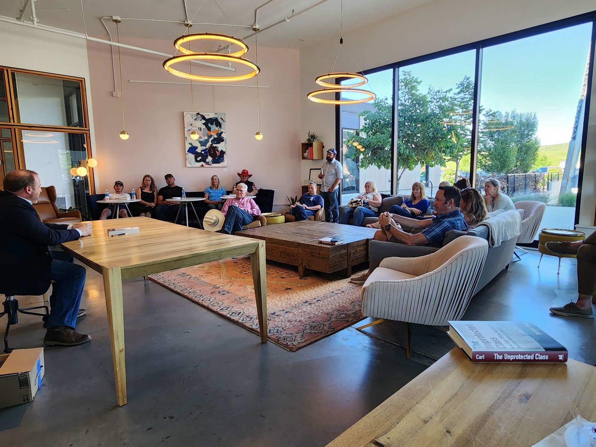 A group of people are sitting around a table in a living room.