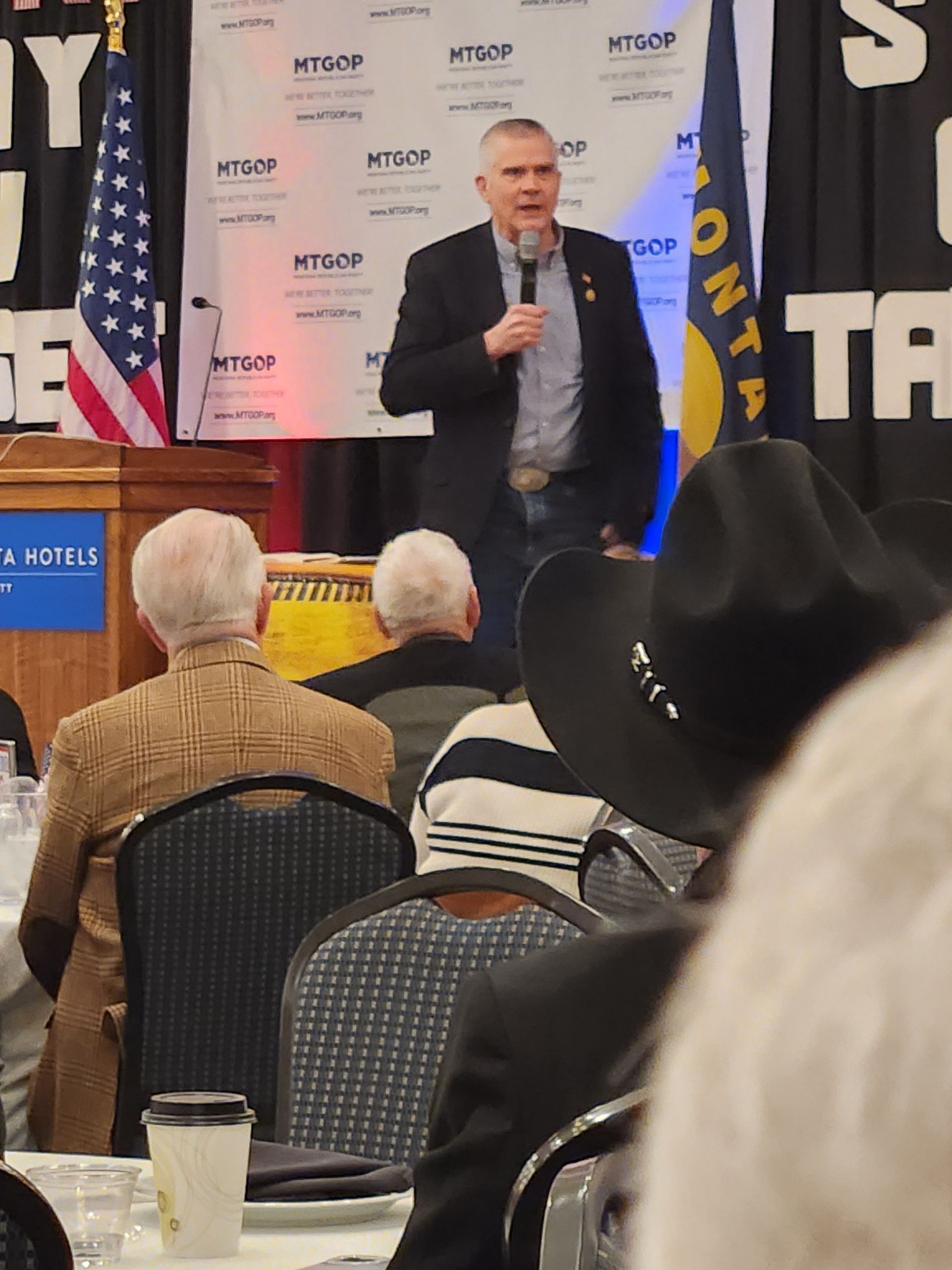 A man is giving a speech in front of a crowd of people