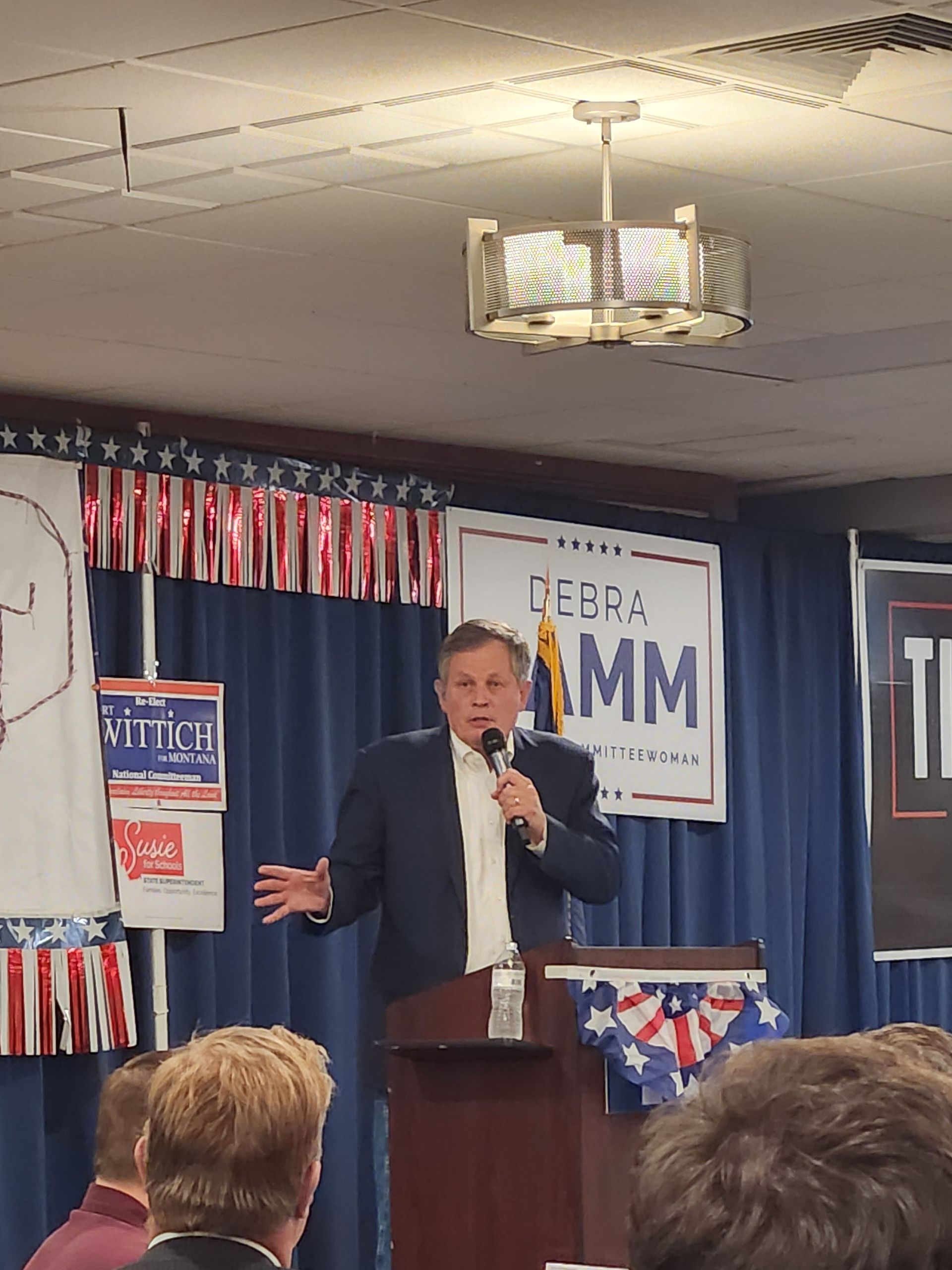 A man stands at a podium speaking into a microphone