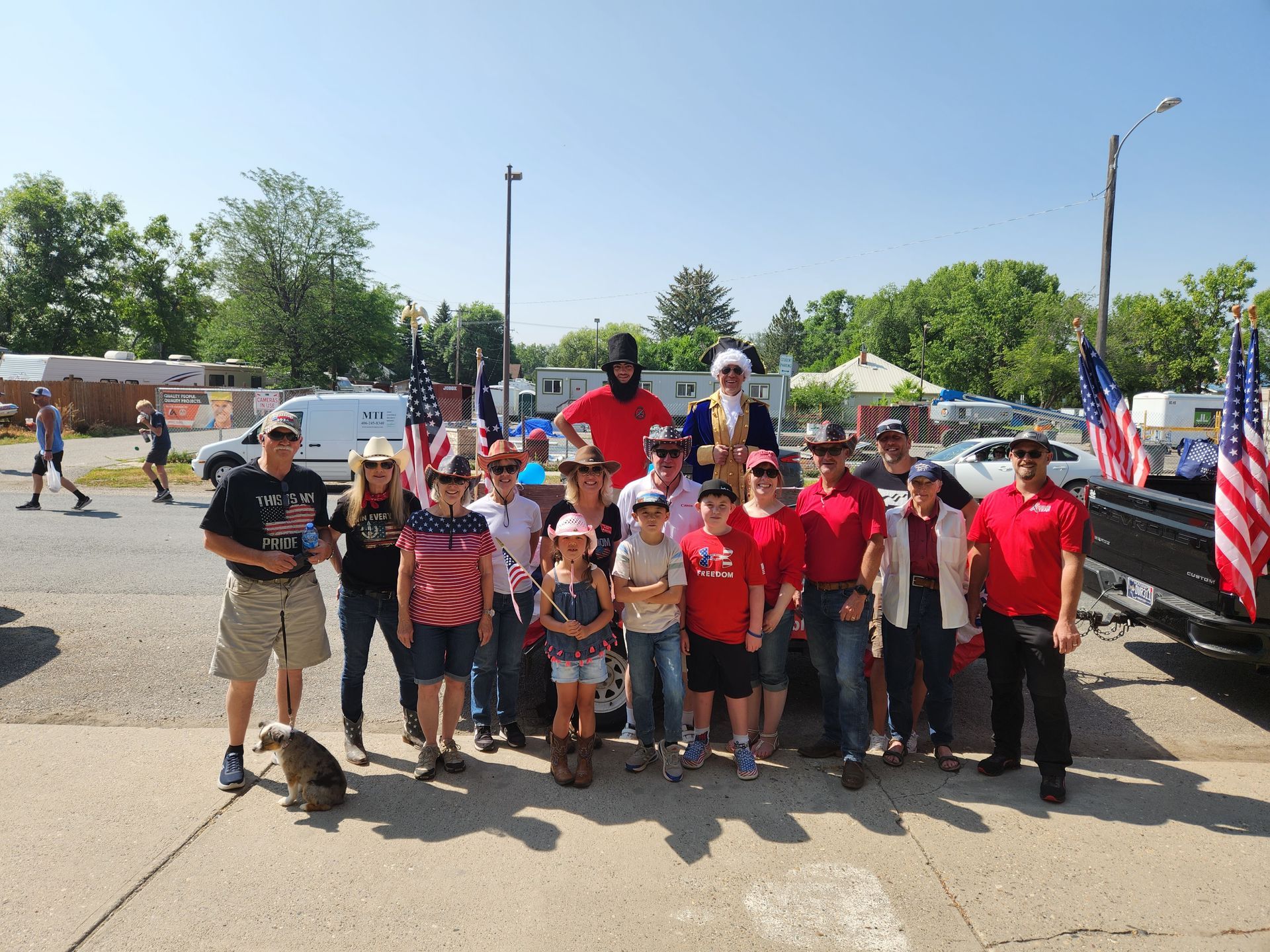 A group of people posing for a picture in front of a truck