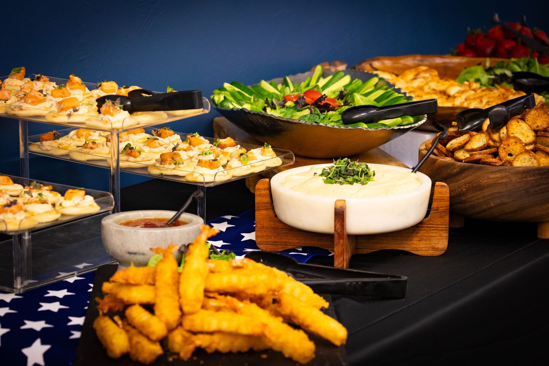 A table topped with a variety of food including french fries and dip.