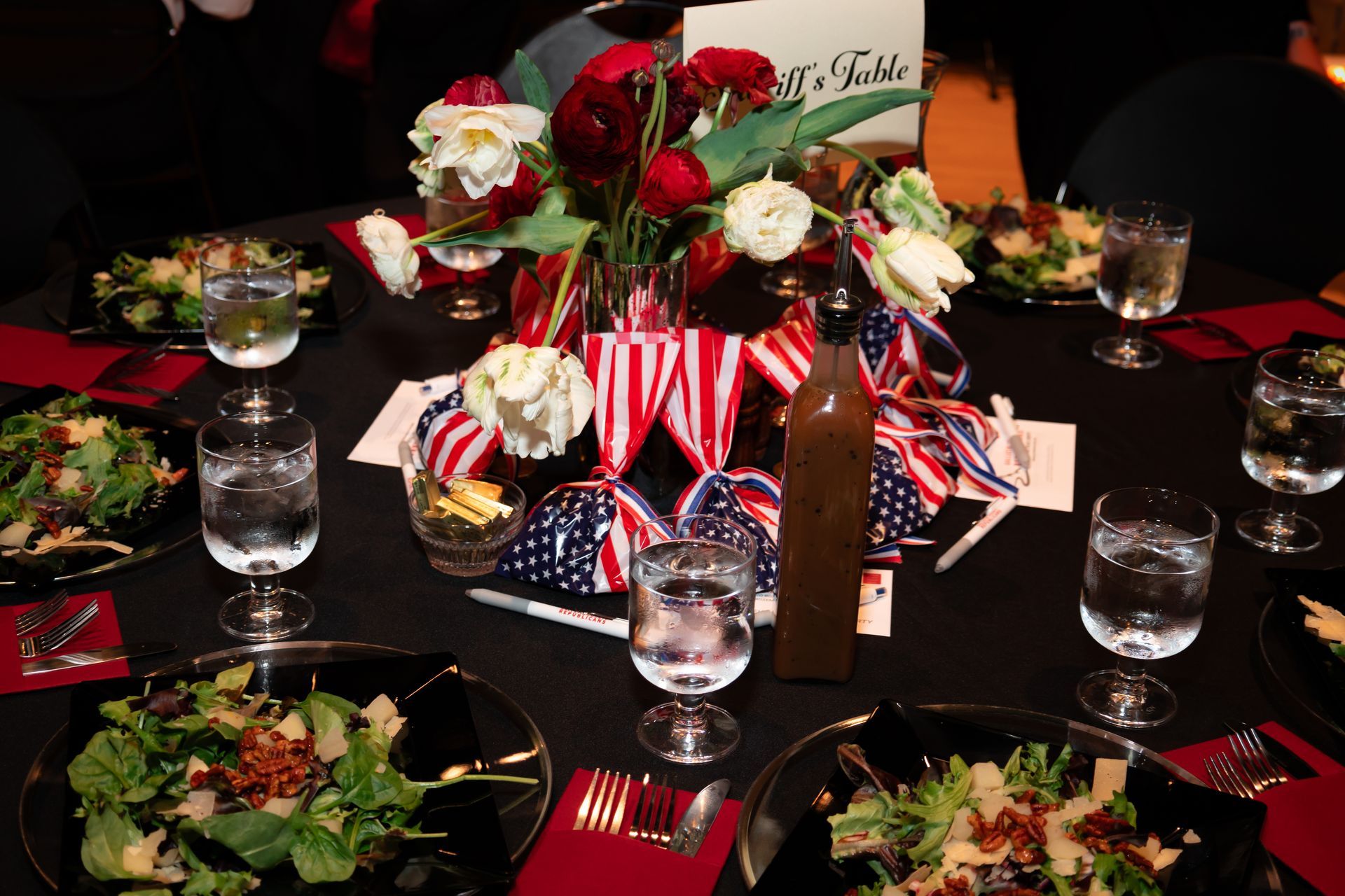 A table with plates of food and a sign that says a table