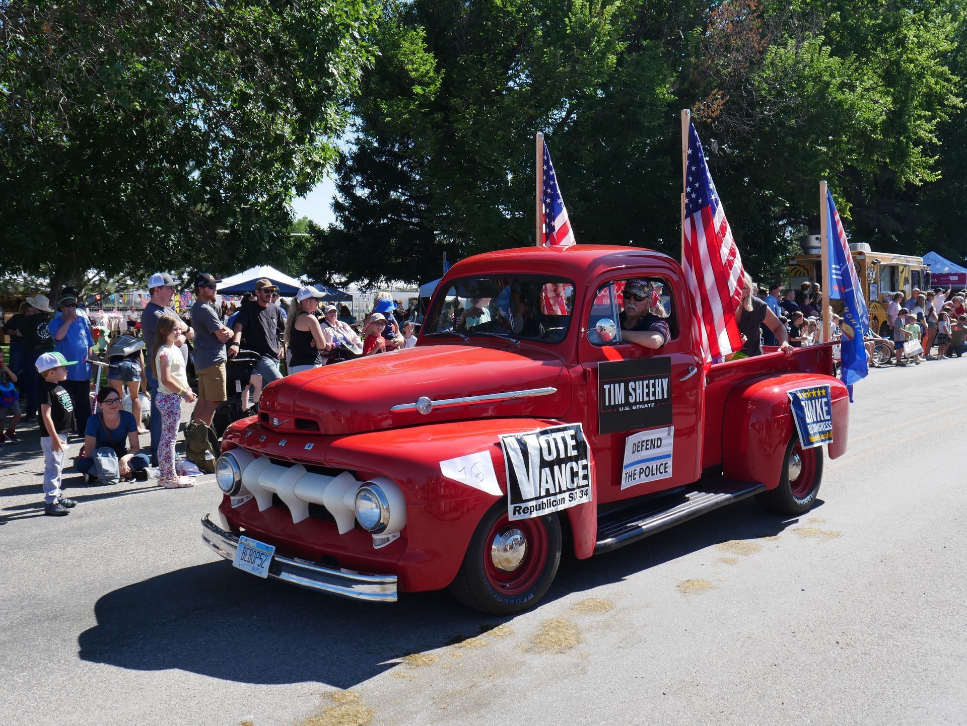 A red truck with a sign that says vote police on it