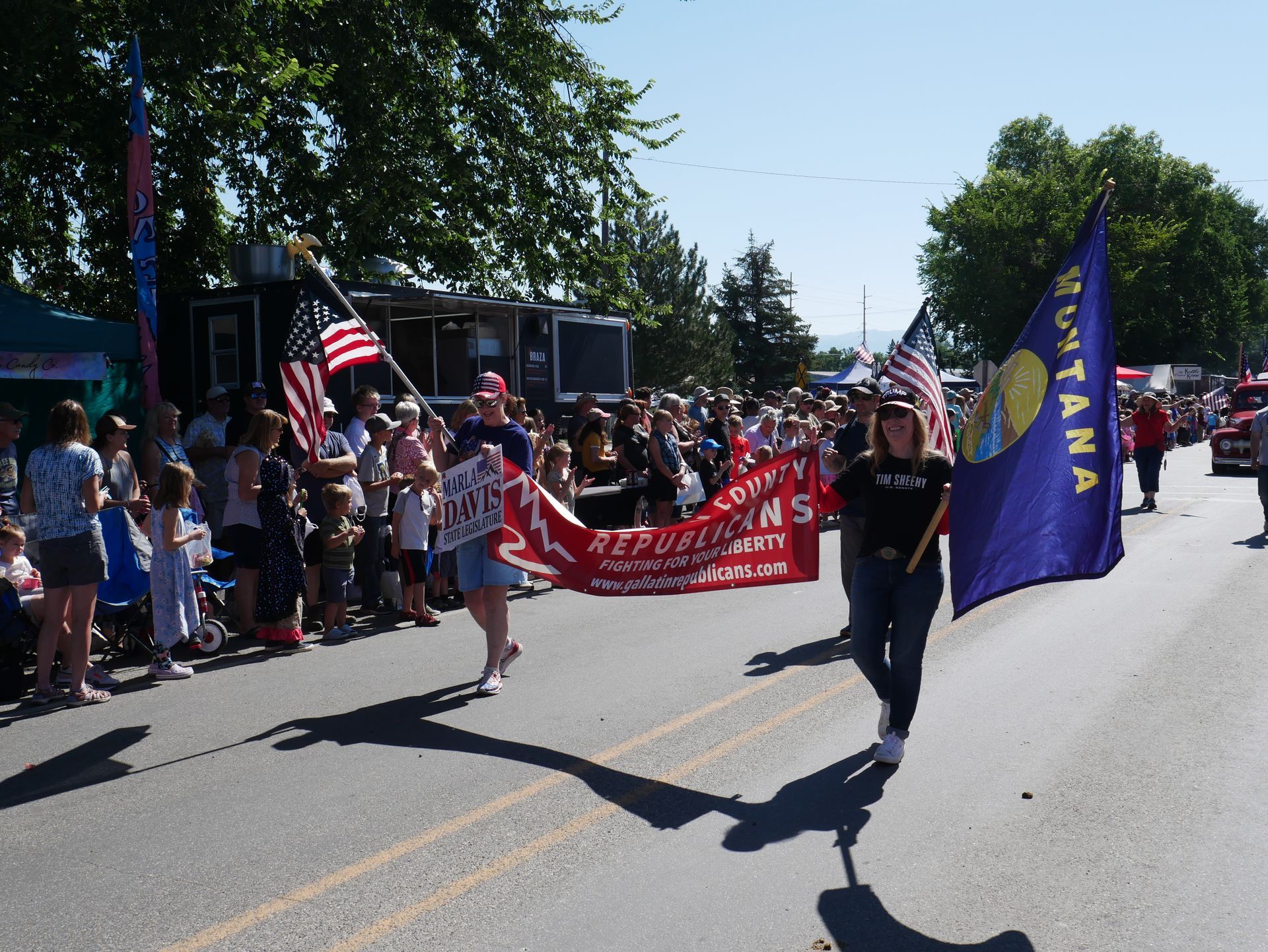 A woman in a parade holding a montana flag