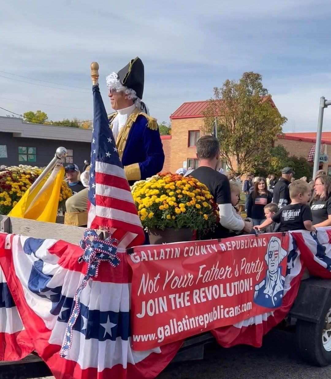 A float in a parade has a sign that says 
