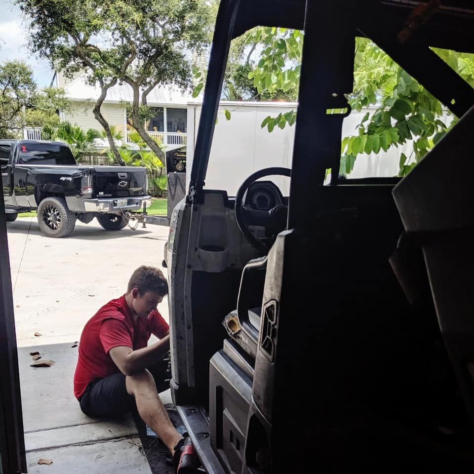 A man in a red shirt is working on a vehicle — St. Augustine, FL — Wide Open Mobile Tech