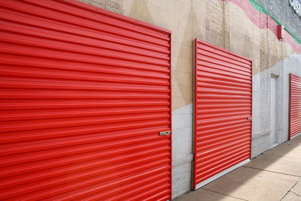 A Row of Red Garage Doors on the Side of a Building — Tableland Self Storage In Maxwell, QLD