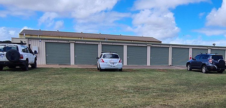 A Row of Garage Doors With Cars Parked in Front of Them — Tableland Self Storage In Atherton, QLD
