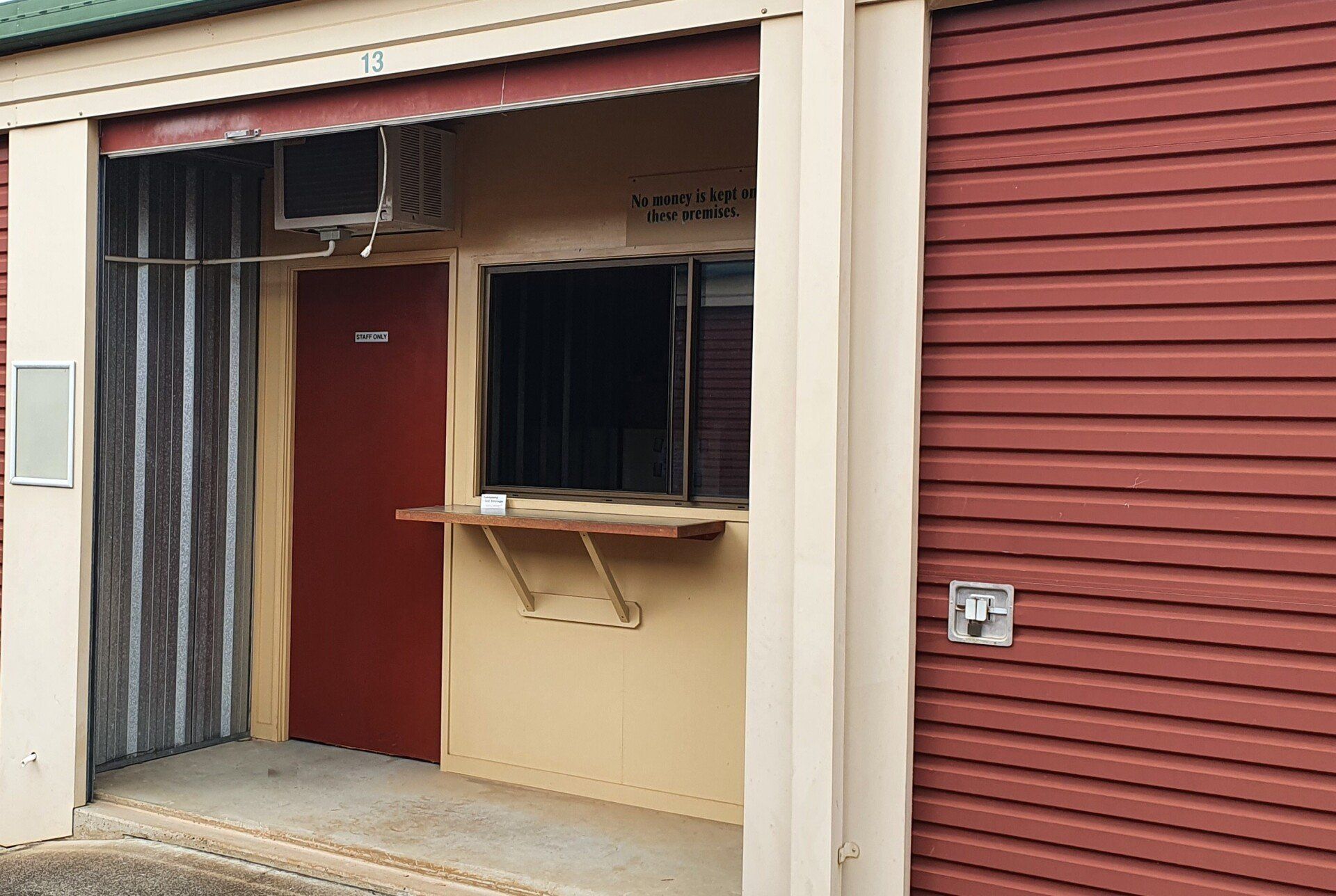 A Small Building With a Red Door and a Window — Tableland Self Storage In Atherton, QLD