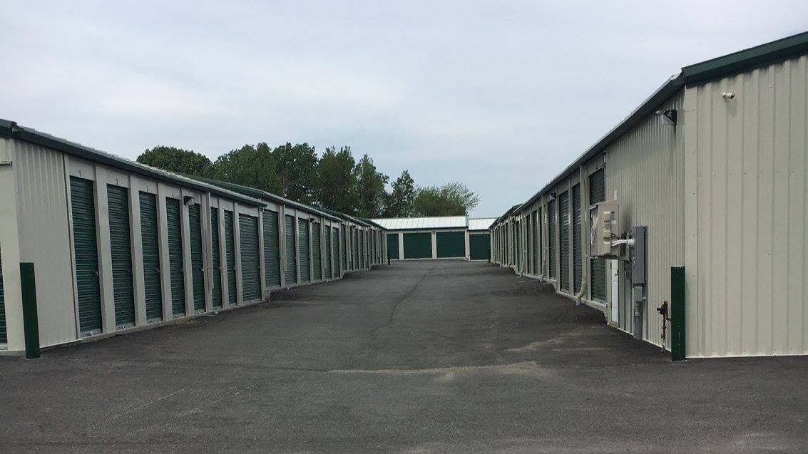 a row of storage units are lined up in a parking lot .