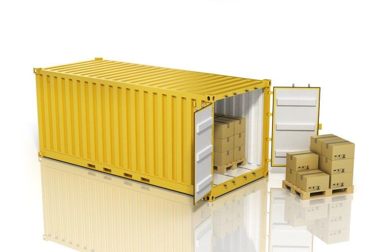 a yellow shipping container filled with boxes and a pallet of boxes