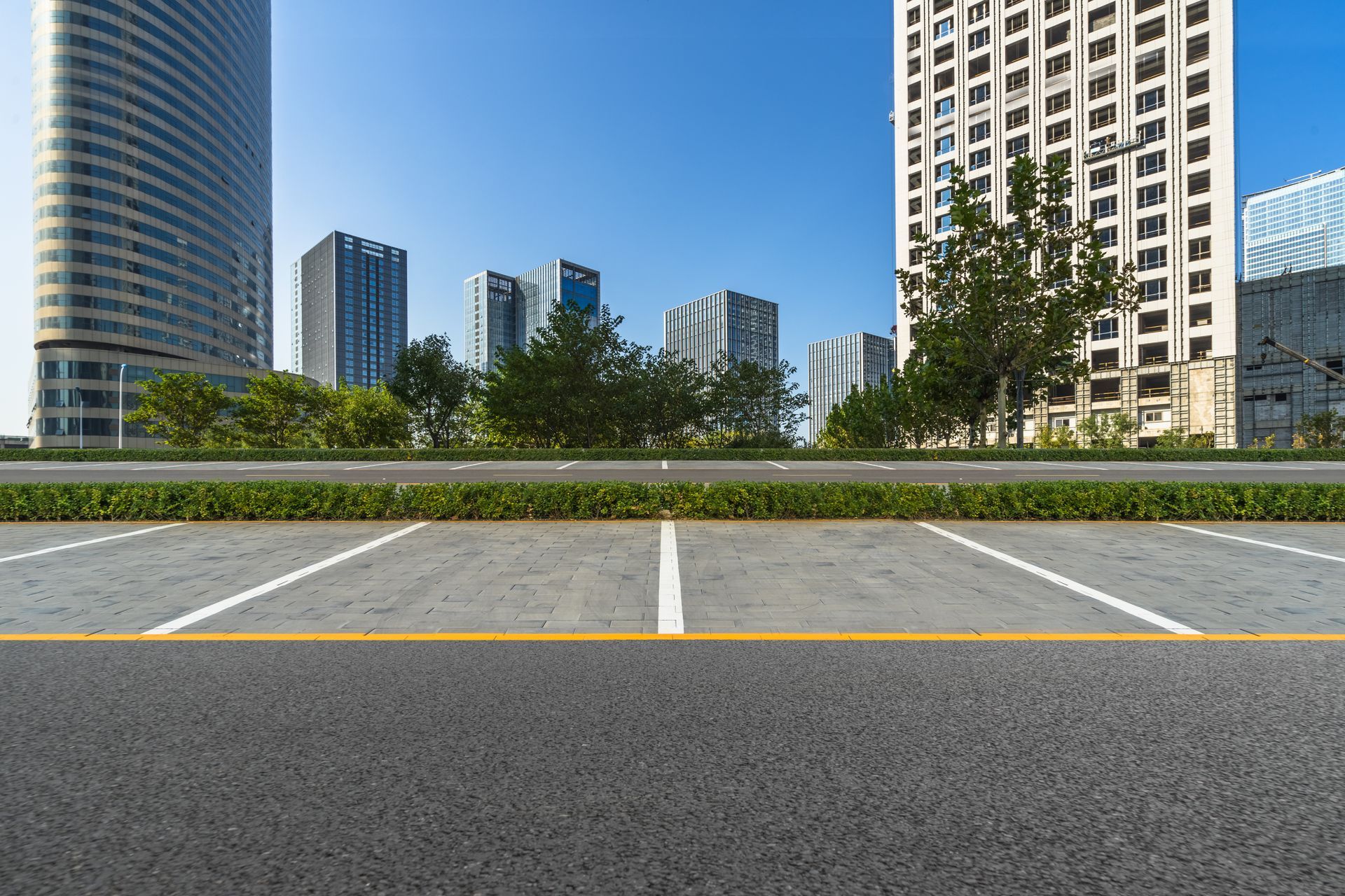 An empty parking lot with a city skyline in the background.
