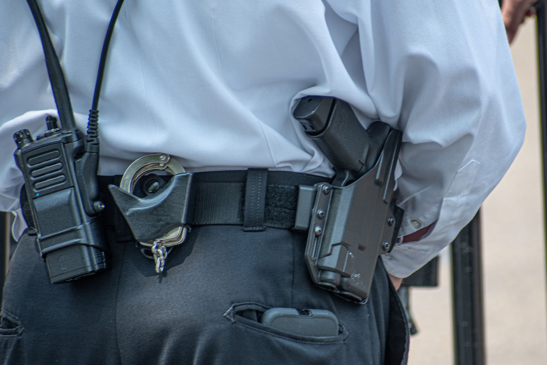 Armed security guard featuring a vigilant guard in uniform holding a firearm outdoors.