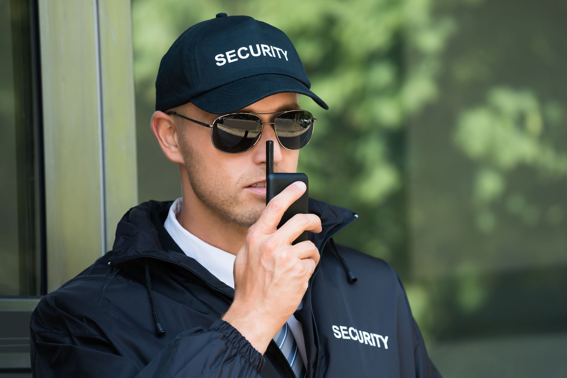 Unarmed security guard service on duty, communicating via walkie-talkie.