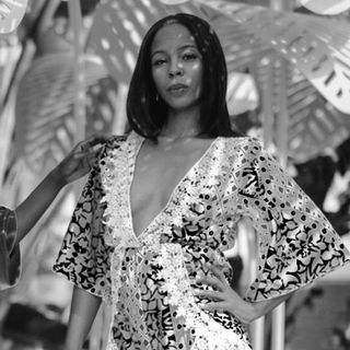 A black and white photo of a woman in a plunging neckline dress.