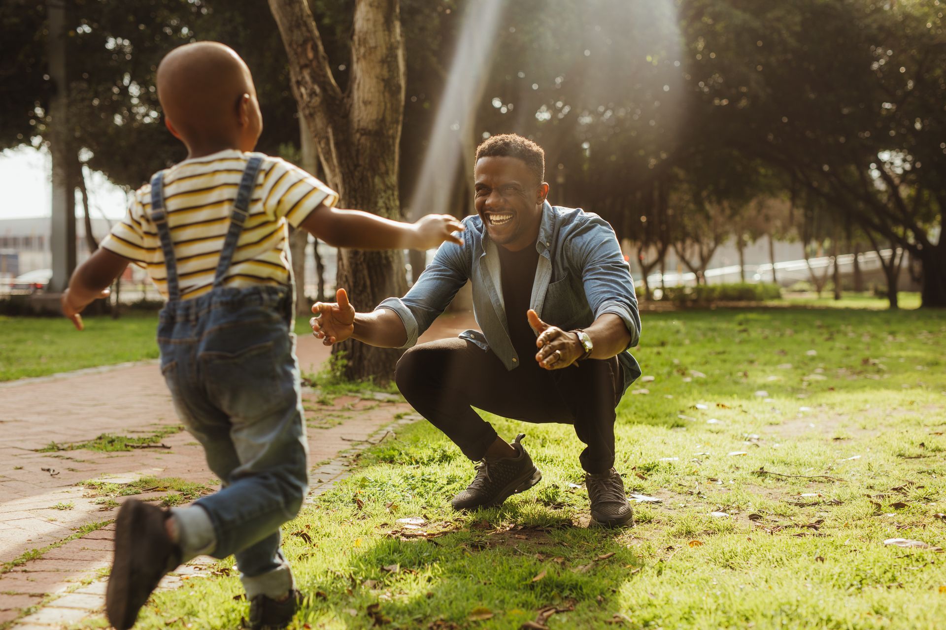 A woman is hugging a little girl in a park.