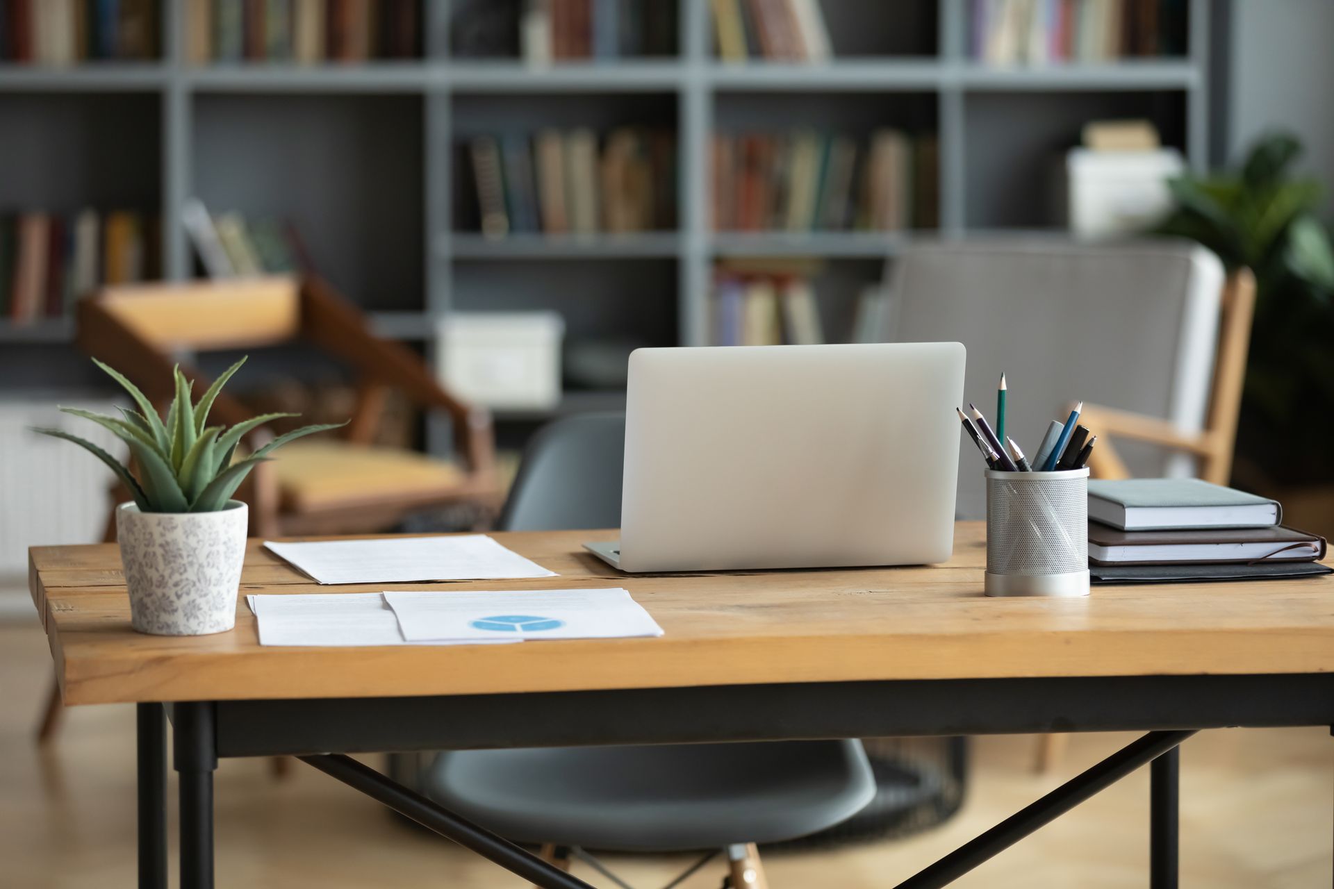 a laptop computer is sitting on a wooden desk in an office .