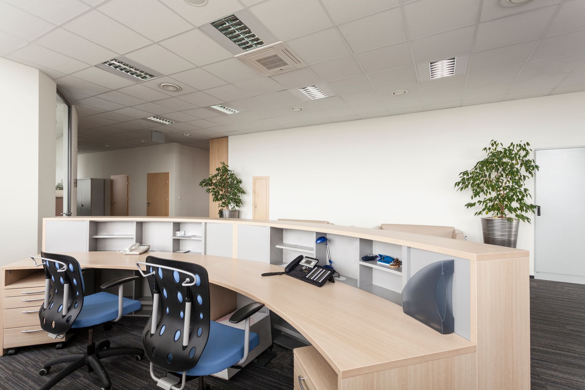 a reception area in an office with two desks and chairs