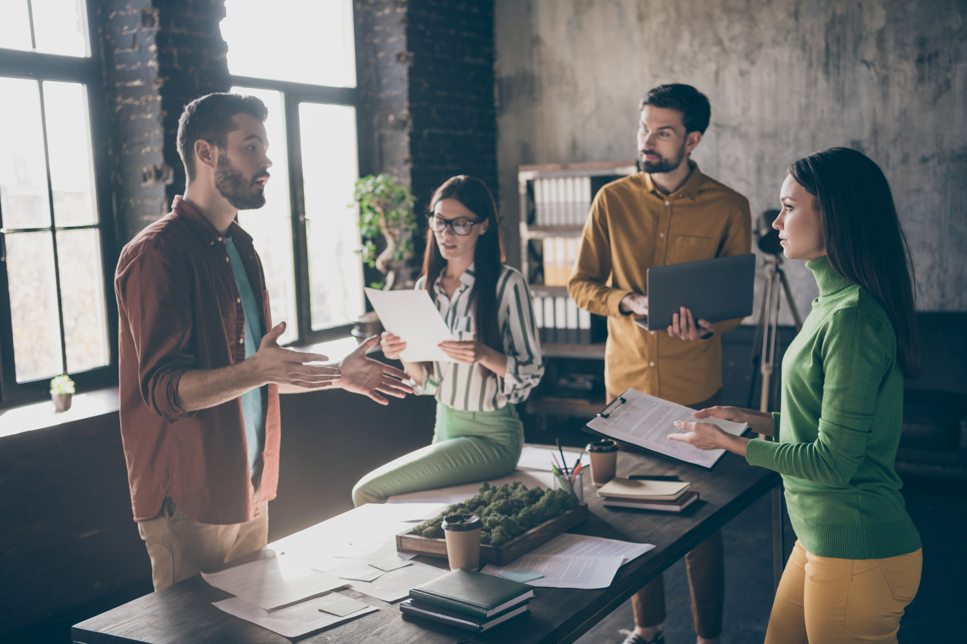 a group of people are sitting around a table having a meeting .