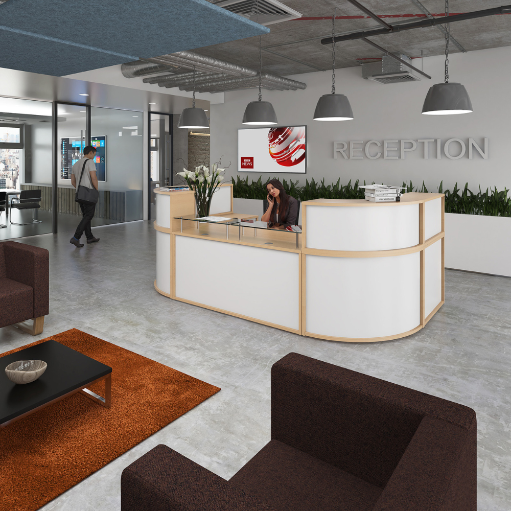 a woman sits at a reception desk in an office