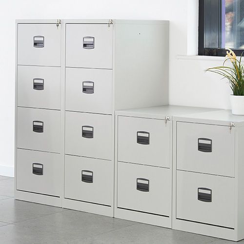 a row of white filing cabinets are sitting next to each other in a room .