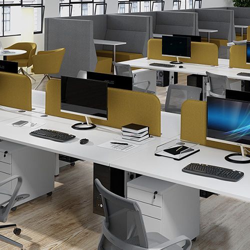 a row of desks with computers and keyboards in an office .
