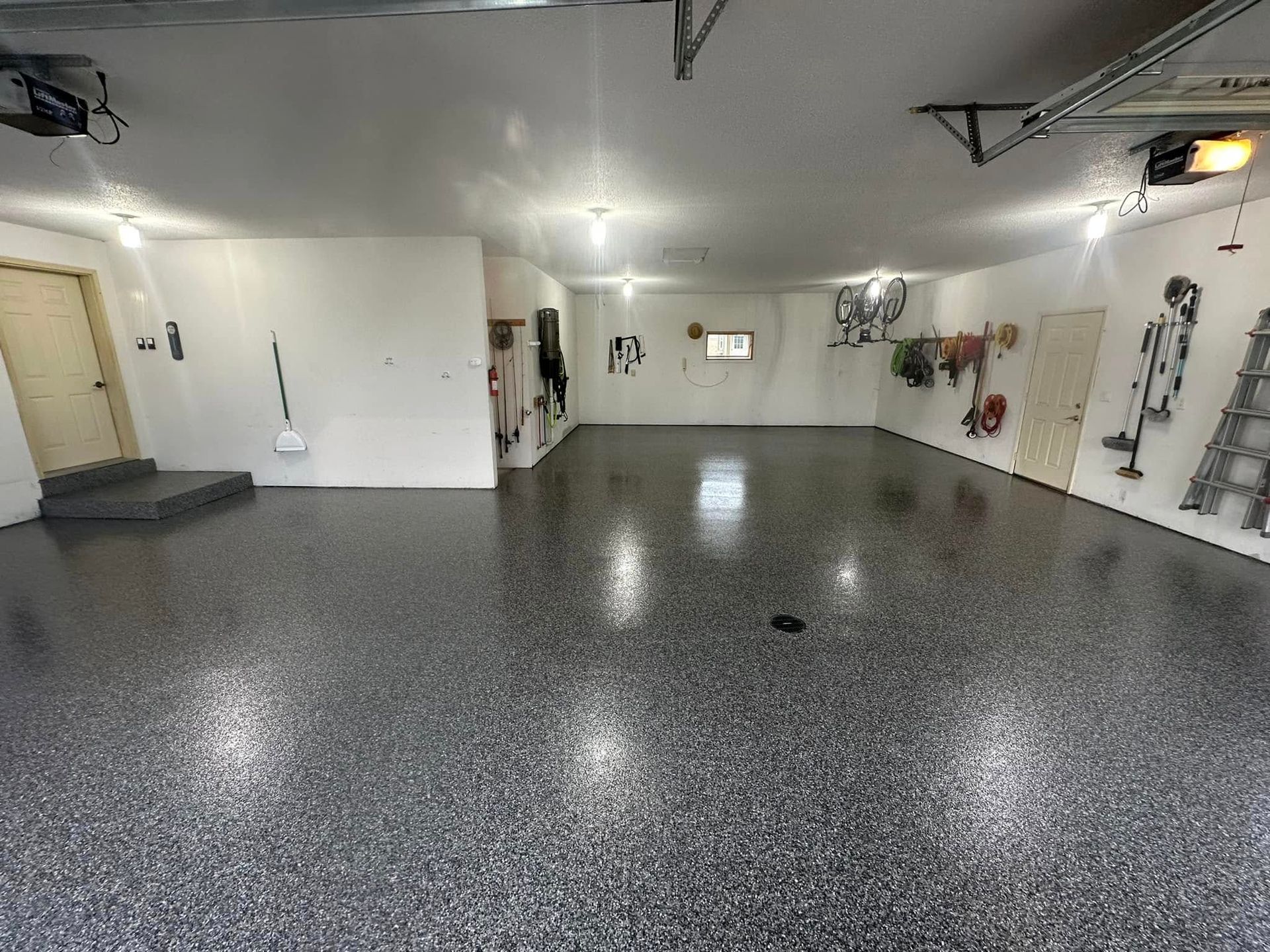 A large empty garage with a gray floor and white walls.