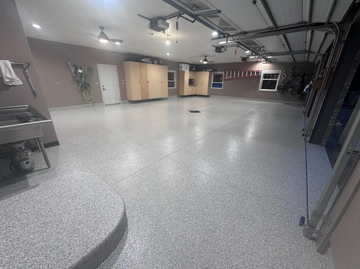A large garage with a garage door open and a sink.