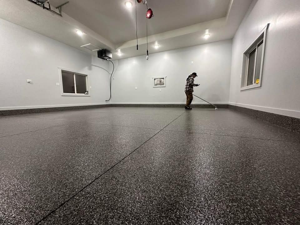 A man is cleaning the floor of a garage with a mop.